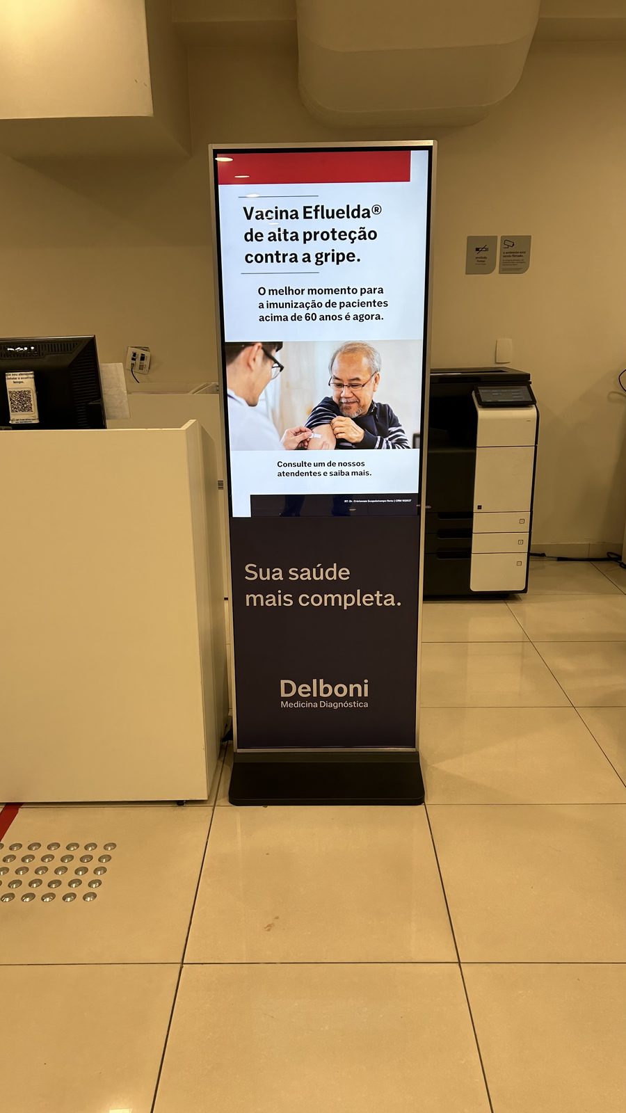 Totem com campanha de vacina Efluelda contra gripe em laboratório Delboni